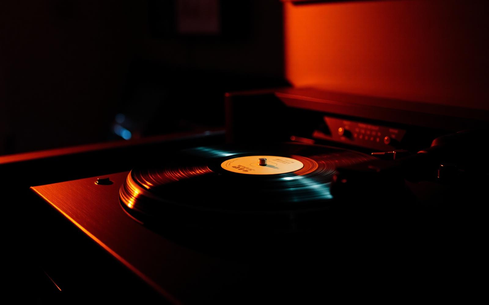 A vinyl record spinning on a turntable in a dimly lit listening bar